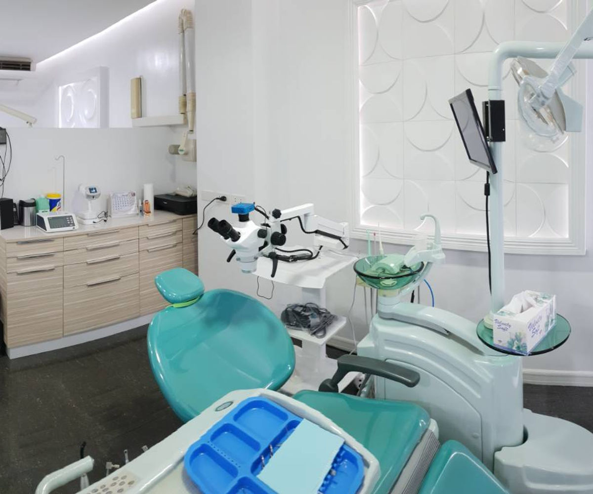 Treatment room with a dental operating microscope beside the chair